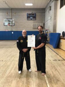 a black belt being awarded a dan certificate