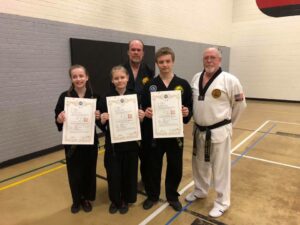multiple black belts being awarded their dan certificates
