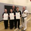 multiple black belts being awarded their dan certificates