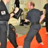 a black belt preparing to strike a focus pad