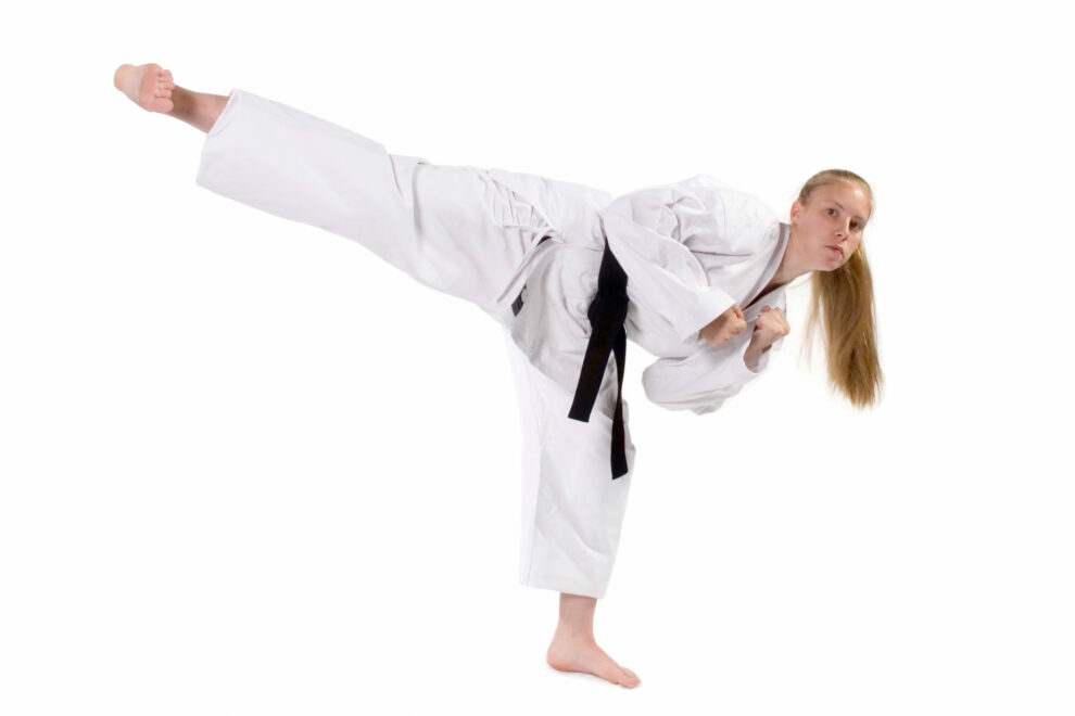a black belt delivering a side kick